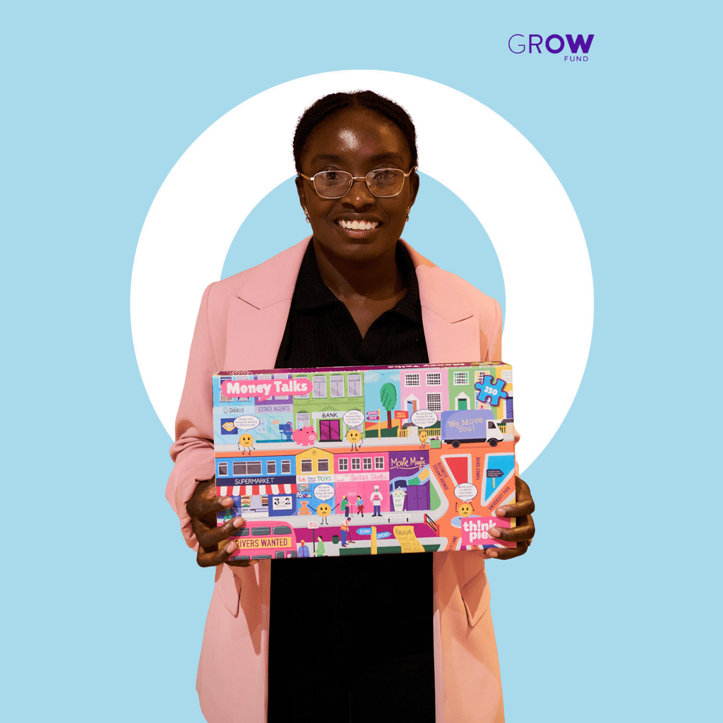 Christina holding the Think Pieces boardgame while smiling